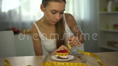 体重不足的女孩用胶带测量蛋糕，害怕体重增加